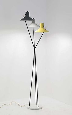 a lamp that is on top of a white floor next to a light fixture with a yellow shade