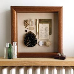 a wooden frame with a clock and other items on it next to a radiator