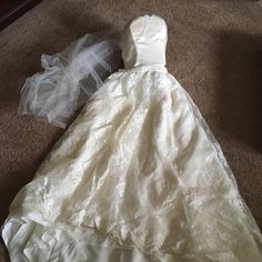 a white dress laying on the floor next to a plastic bag