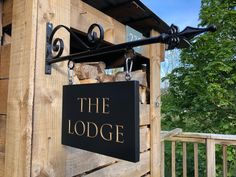 the lodge sign is hanging on the side of a wooden structure with metal brackets and hooks