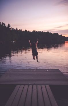 a person jumping into the water from a dock