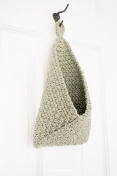 a crocheted bag hanging on a door handle with a hook in the middle