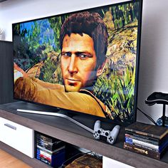 a flat screen tv sitting on top of a wooden shelf