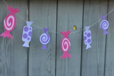 some pink and purple decorations hanging from a line