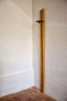 a wooden pole in the corner of a room