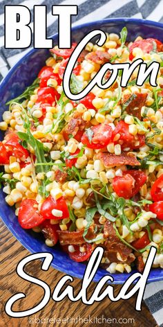 a blue bowl filled with corn salad on top of a wooden table