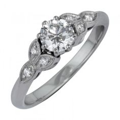 a white gold ring with an oval diamond center and three diamonds on the side, set in