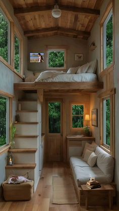 the interior of a tiny house with wood flooring and stairs leading to another room