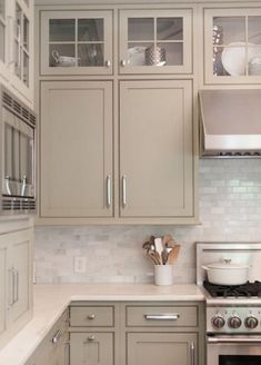 a kitchen with beige cabinets and white counter tops