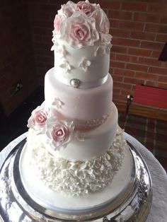 three tiered wedding cake with pink roses on top