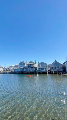 the water is crystal clear and there are houses in the background