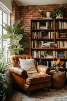 a living room filled with furniture and bookshelves next to a large window covered in plants