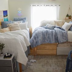 a bed room with two beds covered in blankets and pillows