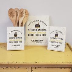 three wooden spoons are sitting next to each other on a table with small bags