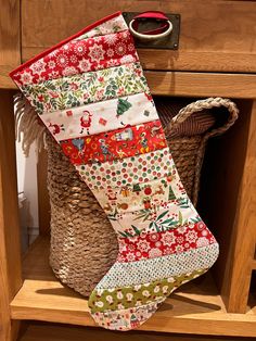 a christmas stocking hanging from a wooden shelf next to a basket and other items