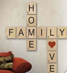 scrabble tiles spelling the word family love on a red couch in front of a white wall