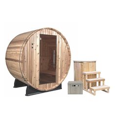 a wooden barrel sauna with steps next to it and another item in the background