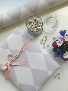 a present box sitting on top of a table next to some flowers and other items