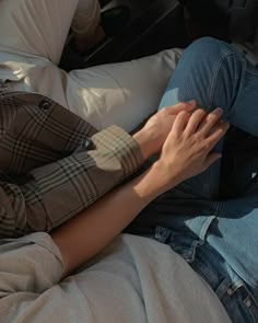 a man laying on top of a bed next to a woman with her hands in his lap