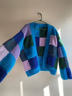 a blue and purple sweater hanging from a hook