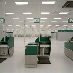 an empty warehouse filled with lots of green and white counters in the middle of it