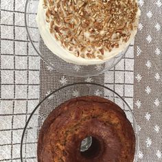 two cakes sitting on top of glass plates next to each other