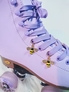 a pair of roller skates with bee charms on them