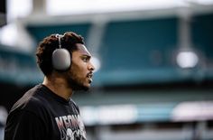 a man wearing headphones in front of a stadium