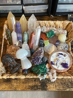 a basket filled with lots of different types of rocks and crystals on top of a wooden table