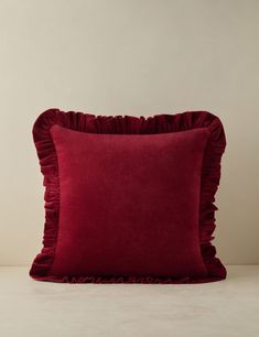 a red pillow with ruffled edges