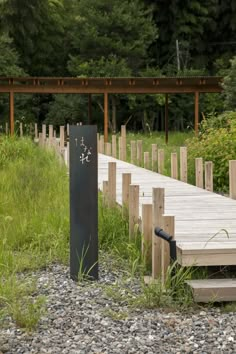 a wooden dock sitting next to a lush green forest