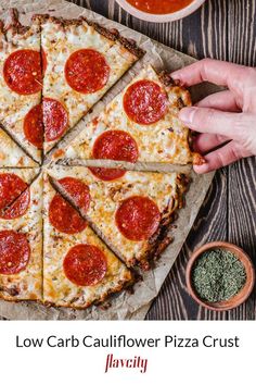 a person holding a slice of pizza with pepperoni on it and the text low carb cauliflower pizza crust