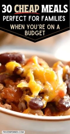 a white bowl filled with chili cheese and beans on top of a table next to a fork