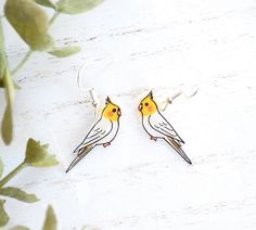 two yellow and white birds sitting on top of each other's earwires