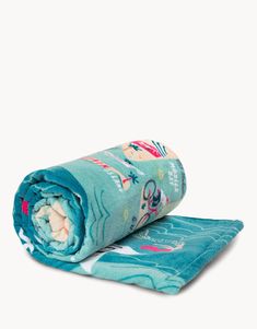 a rolled up blue towel on top of a white surface with an animal print design