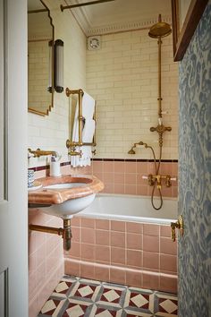 a bath room with a sink and a bath tub next to a mirror on the wall