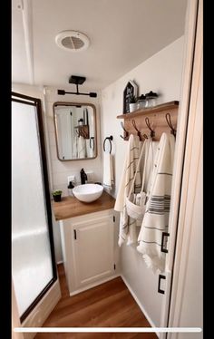 two pictures of a bathroom with towels hanging on the wall and sink in the corner