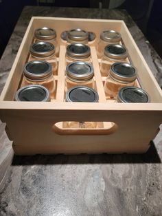 an open drawer with jars in it on a counter