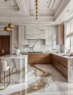 an elegant kitchen with marble counter tops and gold pendant lights hanging from the ceiling over the island