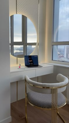 a laptop computer sitting on top of a desk in front of a window with a view