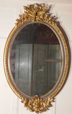 a mirror hanging on the side of a wall next to a wooden door and window