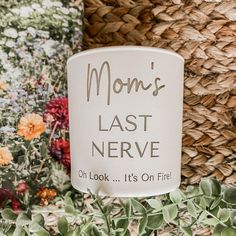 mom's last nerve coffee mug sitting on top of flowers and plants