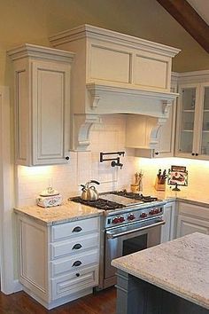 a kitchen with white cabinets and an island