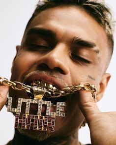 a man with chains around his mouth biting into the word'love'written on it