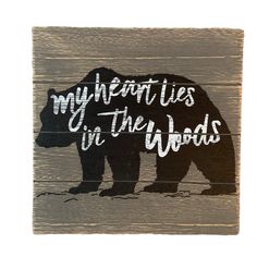 a wooden sign with the words my heart lies in the woods on it and a bear silhouette