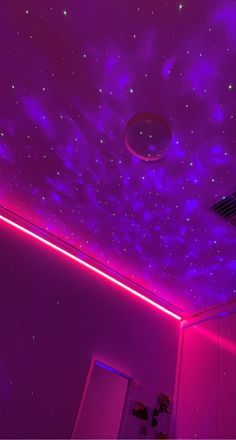 a room with purple lighting and stars on the ceiling