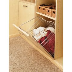 an open cabinet with baskets and other items in the bottom drawer, on carpeted flooring