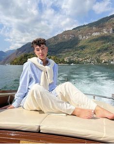 a young man sitting on the back of a boat