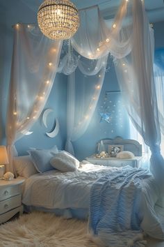 a white bed sitting under a chandelier in a bedroom next to a window