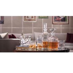 an assortment of liquor glasses and decanters on a table in a living room